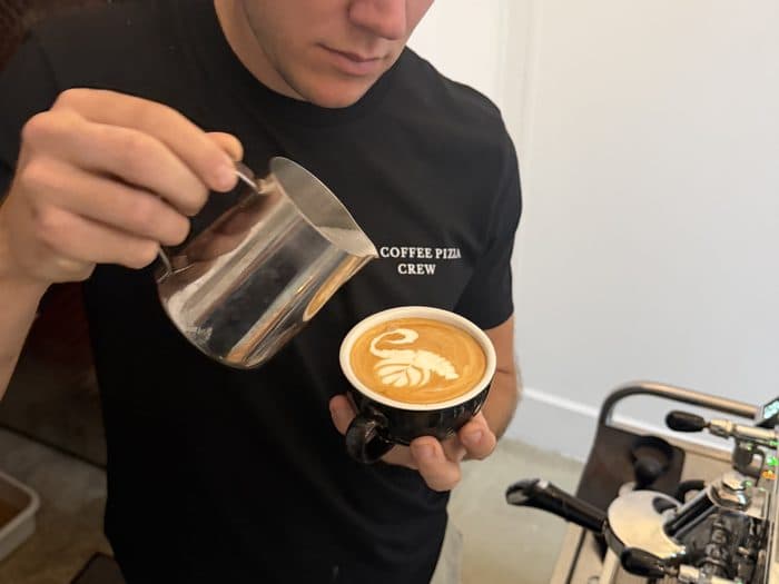 Milchschaum wird in den Espresso gegossen