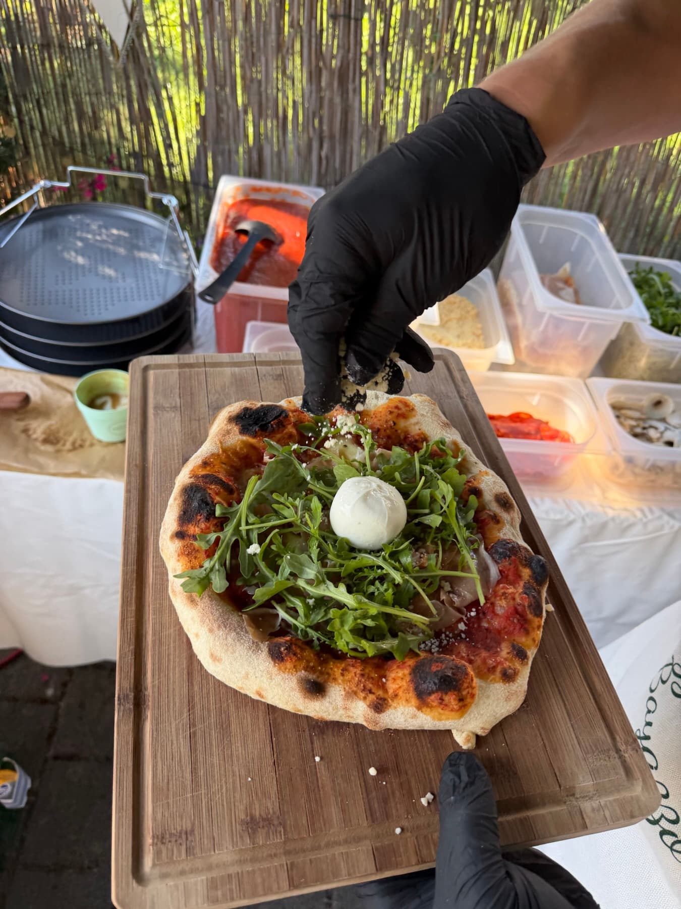 Pizza mit Rucola und Burrata auf einem Holzbrett