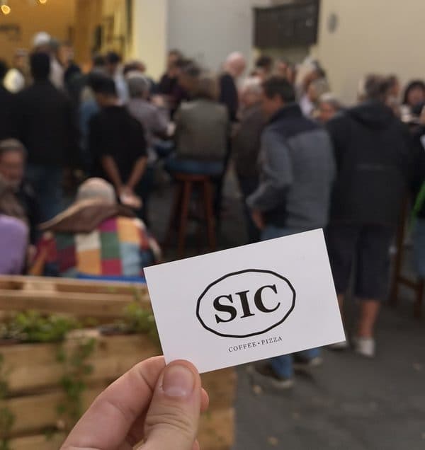 Visitenkarte von SIC Coffee Pizza vor den Gästen eines Straßenfests