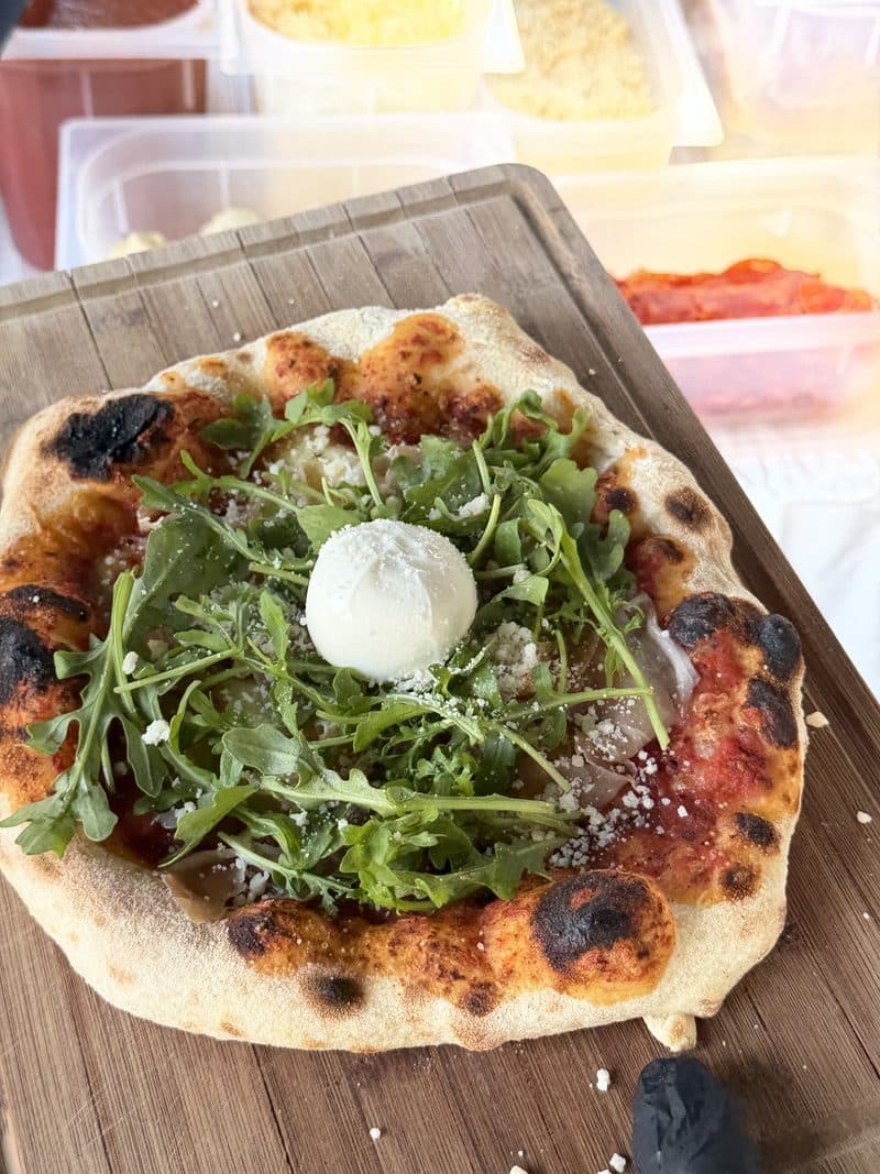 Pizza mit Burrata und Rucola frisch aus dem mobilen Ofen