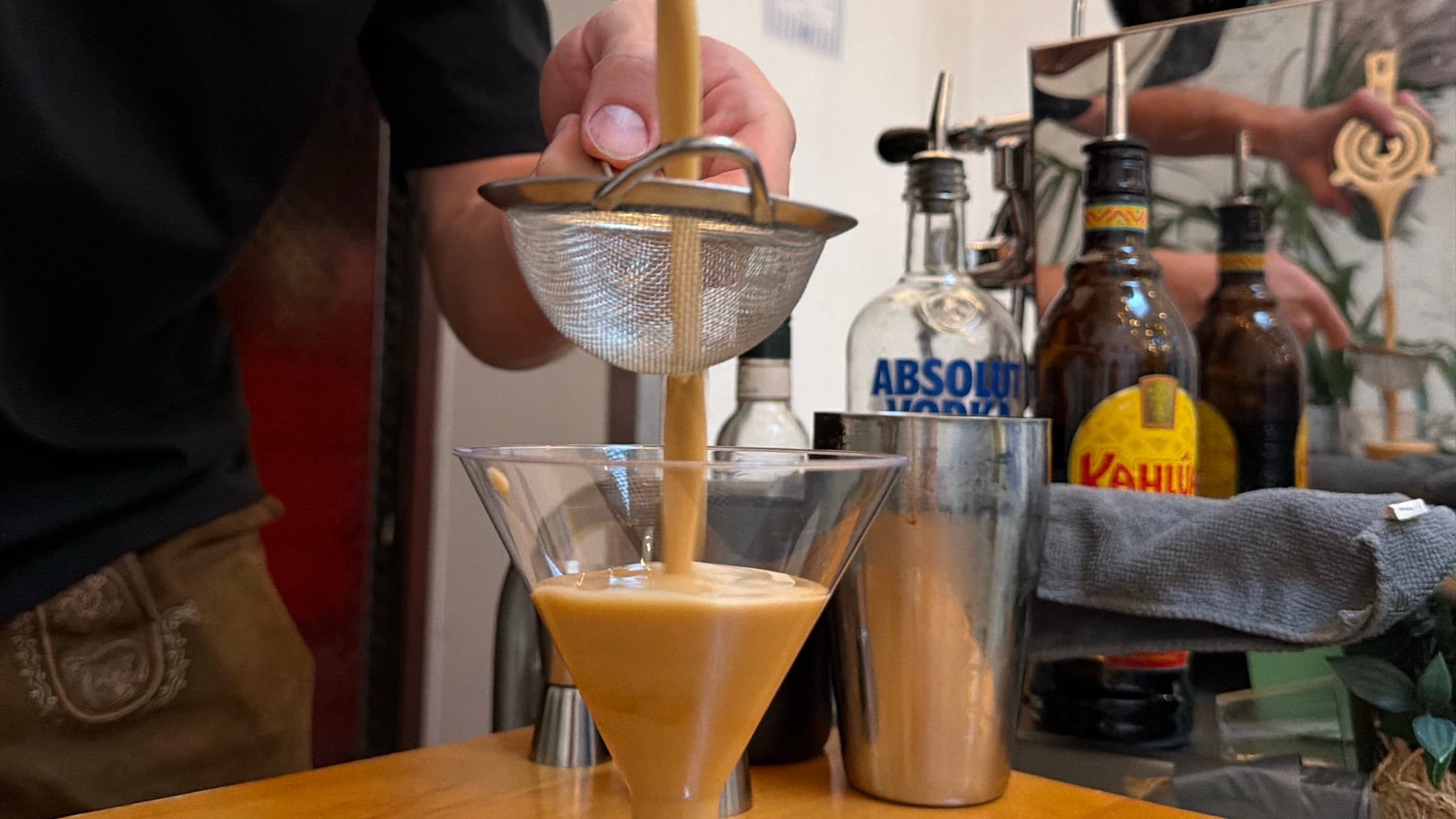 Barista von SIC Coffee Pizza gießt einen Espresso Martini durch ein Sieb ins Glas