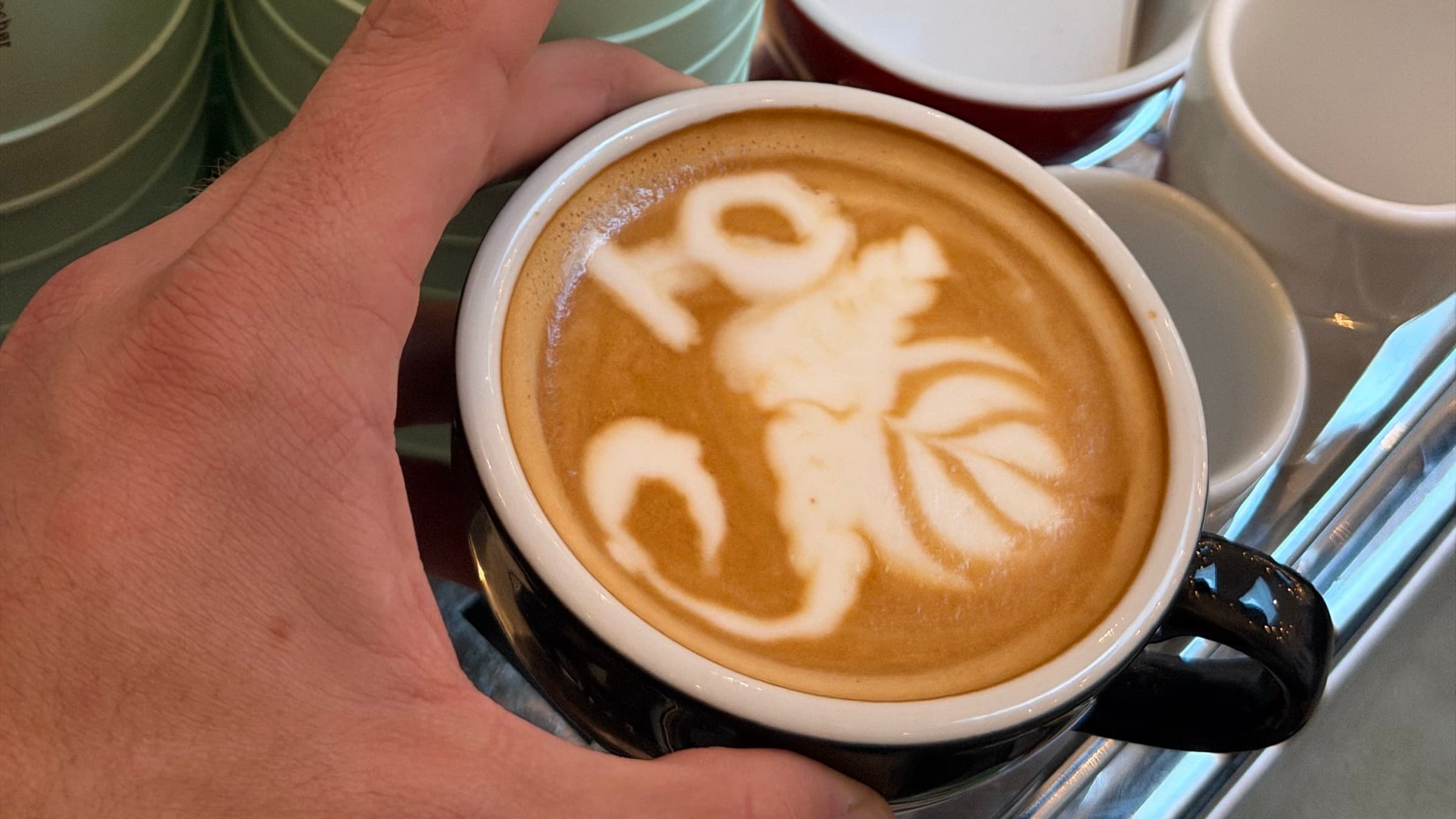 Nahaufnahme eines Cappuccinos mit Latte Art an der mobilen Kaffeebar von SIC Coffee Pizza